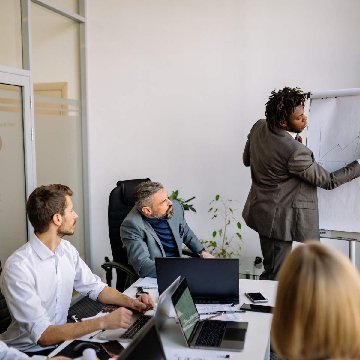 Homem em posição de liderança conduzindo reunião de equipe